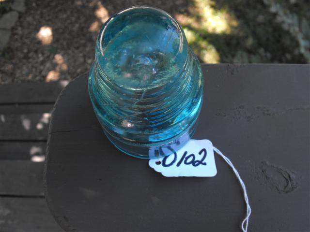 Insulator. Turquoise glass. Etched on front is "